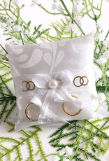 Ringkussentje voor je hond versierd met witte lint en gouden ringen