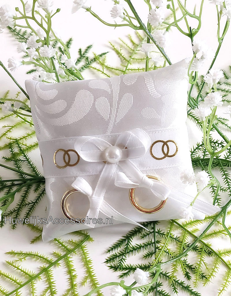 Ringkussentje voor je hond versierd met witte lint en gouden ringen