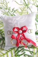 Ringkussentje voor je hond versierd met rode lint en gouden ringen