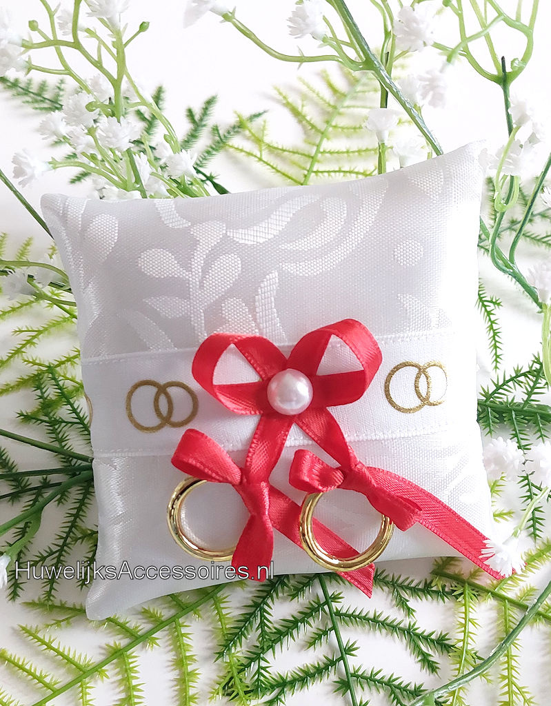 Ringkussentje voor je hond versierd met rode lint en gouden ringen