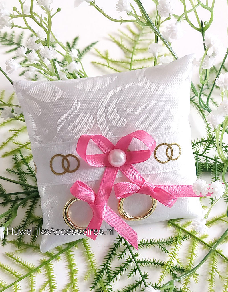 Ringkussentje voor je hond versierd met roze lint en gouden ringen