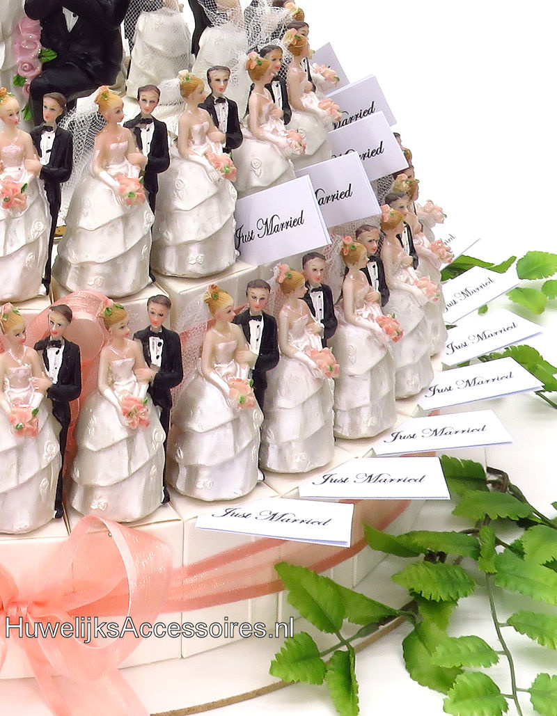 Bruidssuiker taart versierd met bruidsparen met zalm lint