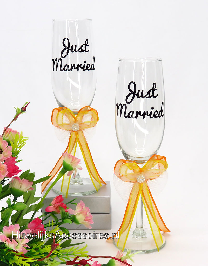 Huwelijk champagneglazen versierd met oranje en geel gekleurde strikjes
