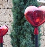 Strahlend rotes Herz aus Glas mit Holzstab