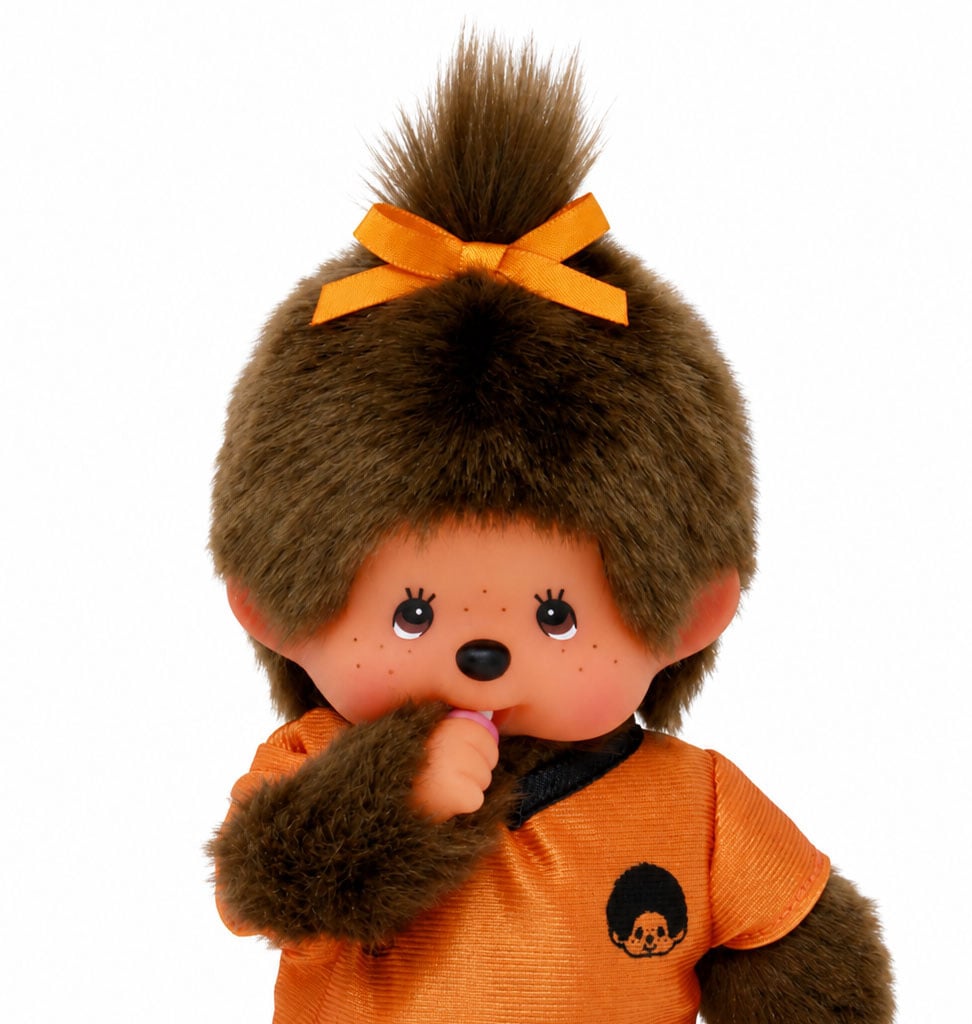 Monchhichi Mädchen aus Monchhichi im orangefarbenen Fußballtrikot / Weltmeisterschaft 2026