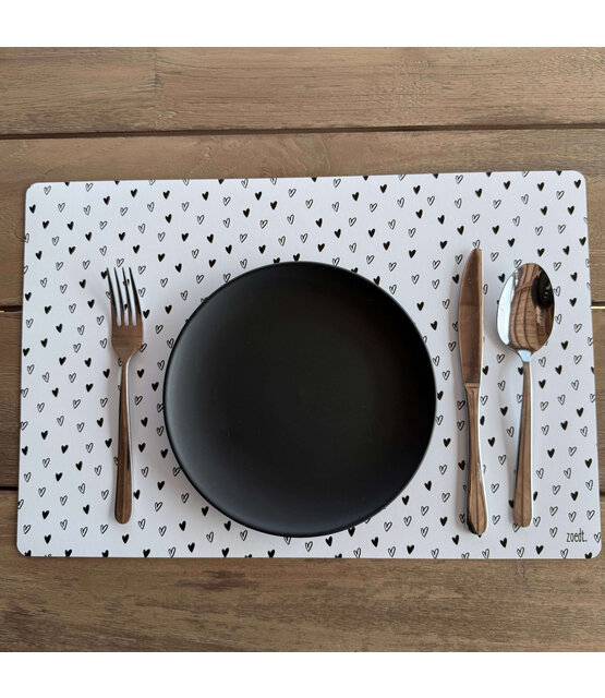 Placemat van wit vinyl met zwart hartjes patroon – een stijlvolle en praktische toevoeging aan jouw eettafel