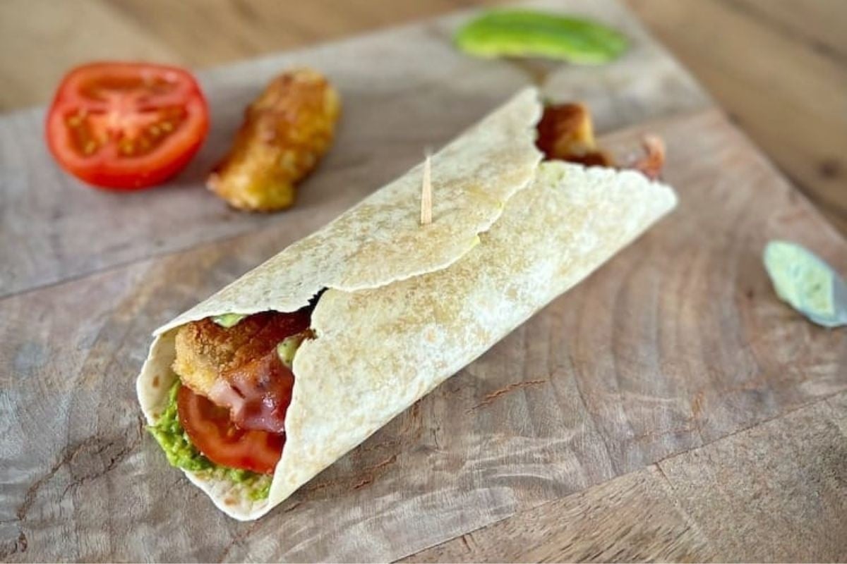 Keto wrap met krokante kip, bacon, avocado, tomaat en ijsbergsla