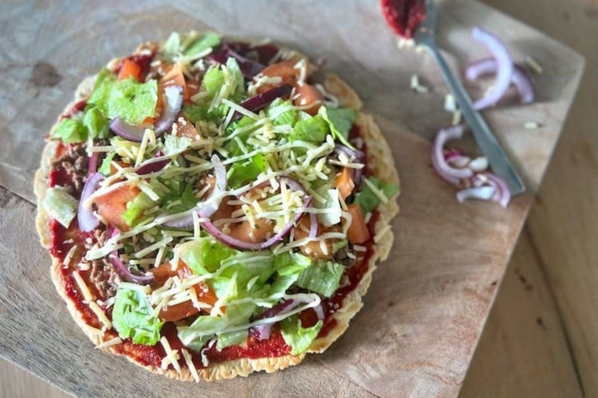 Koolhydraatarme Turkse pizza met gehakt, ijsbergsla, tomaat en rode ui