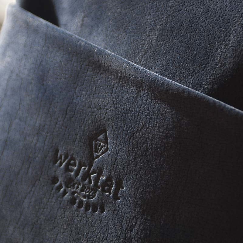 Detail on blue nubuck leather bag with werktat embossing