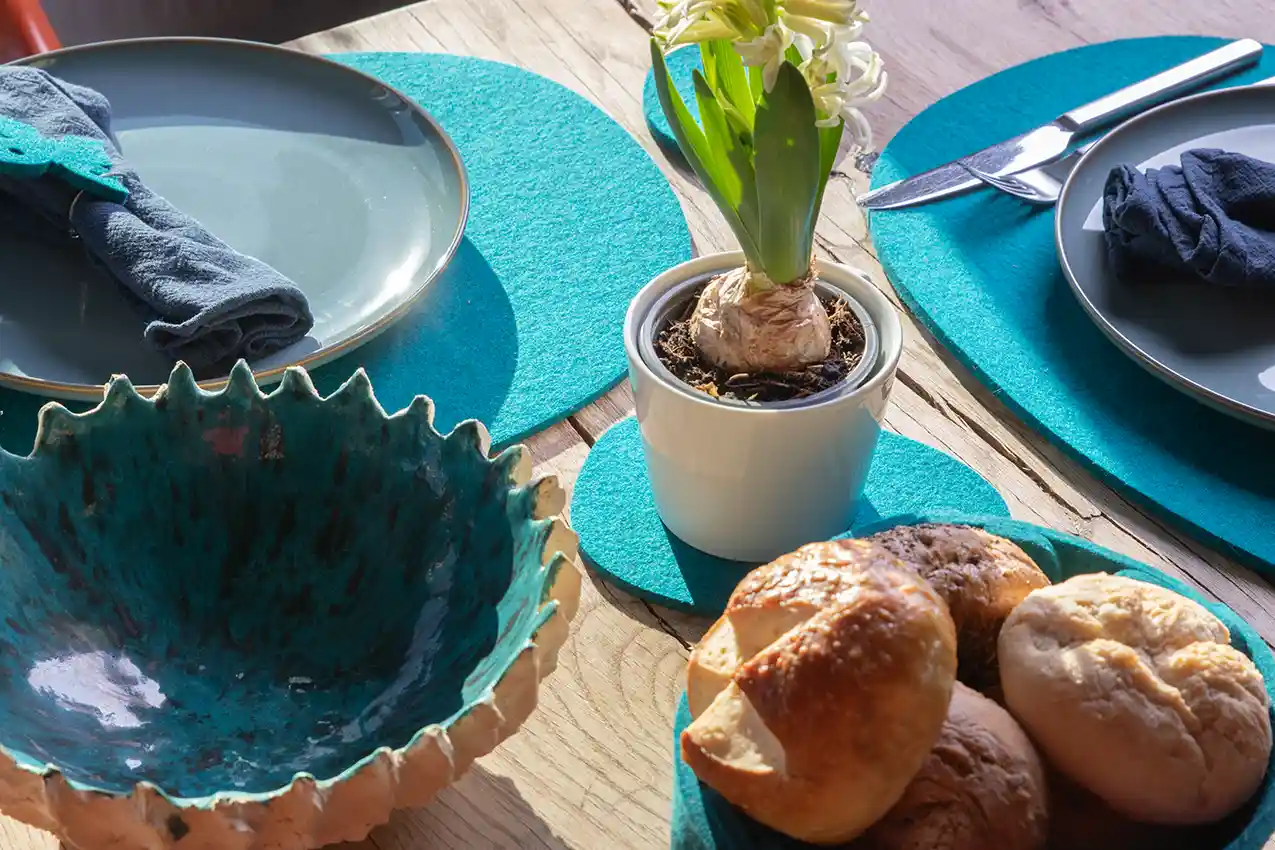 beautifully laid table for breakfast with bread rolls and flower