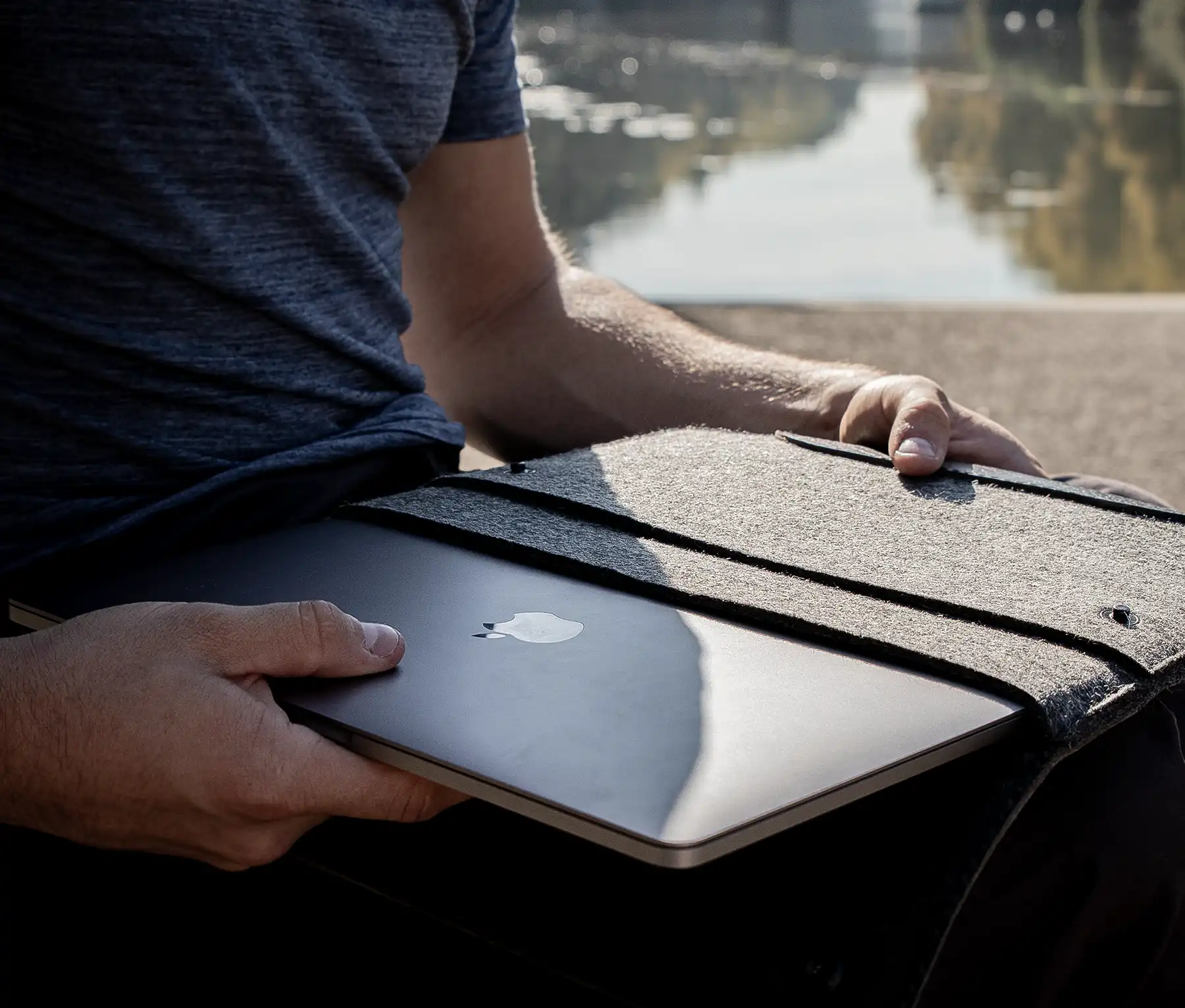 Person packt das MacBook aus einer Hülle aus