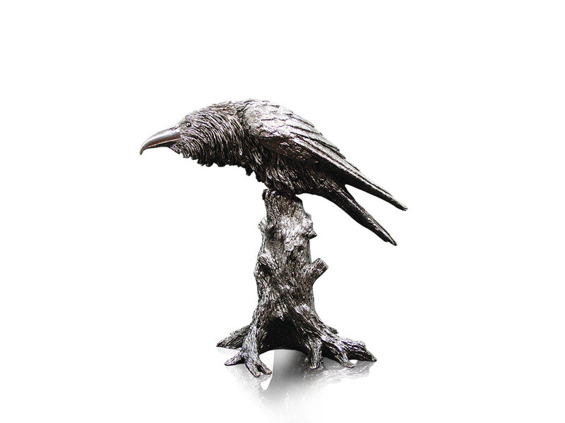 Nickel-plated raven sitting on a tree stump