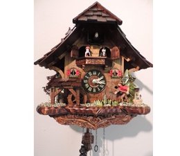 Trenkle Uhren Hermosa 33cm Reloj de cuco con techo de tejas de madera en el Bosque Negro hace con movimiento de cuarzo y de cuco con el movimiento de la danza Angler rueda cifras molino
